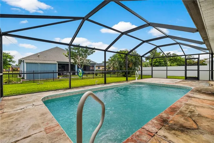 View of pool with a sunroom, glass enclosure, and a patio