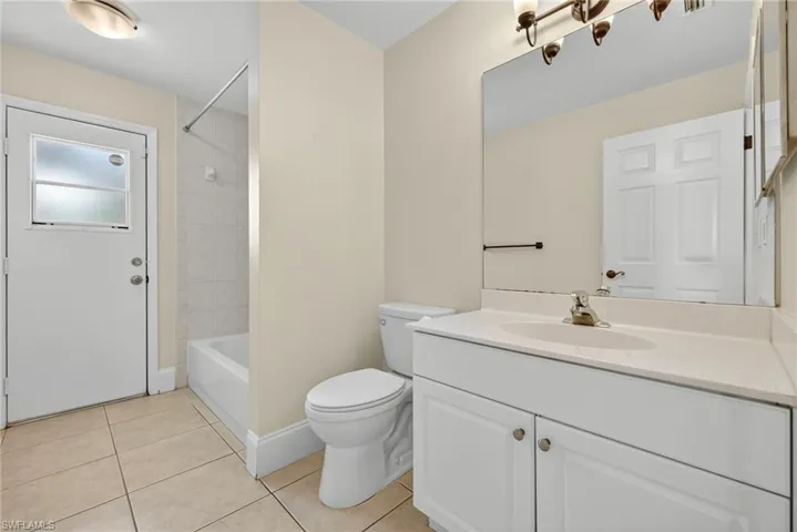 Bathroom with vanity, light tile patterned floors, and  shower combination