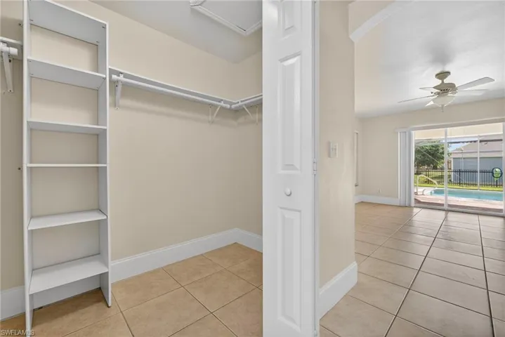 Spacious closet featuring light tile patterned flooring and ceiling fan