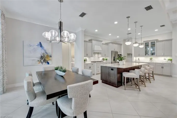 Tiled dining space featuring a notable chandelier and ornamental molding