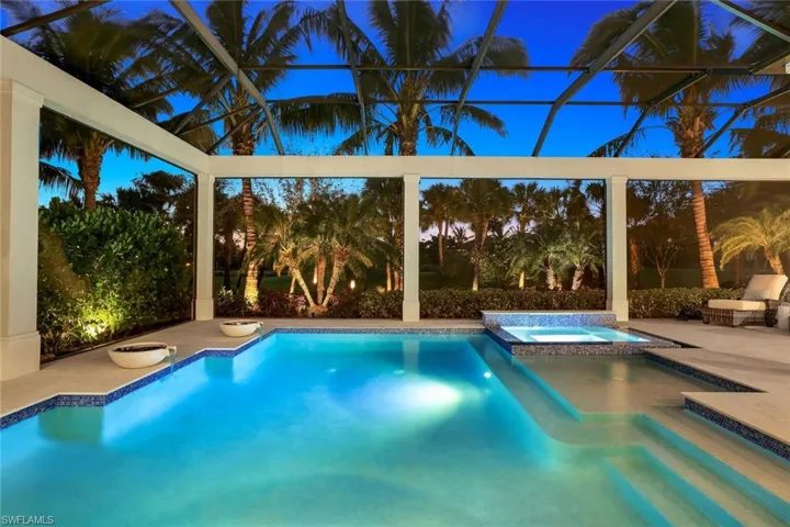 View of swimming pool with a patio, an in ground hot tub, and glass enclosure