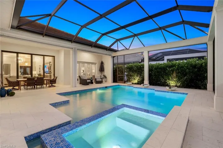View of pool with a patio, outdoor lounge area, glass enclosure, and an in ground hot tub