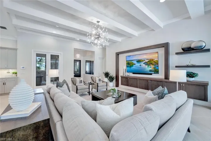 Tiled living room with beamed ceiling and a chandelier