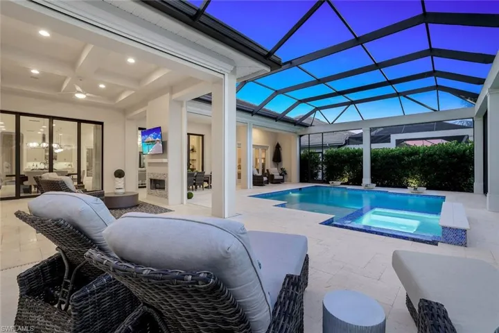 View of pool featuring an in ground hot tub, a patio area, a lanai, ceiling fan, and an outdoor living space
