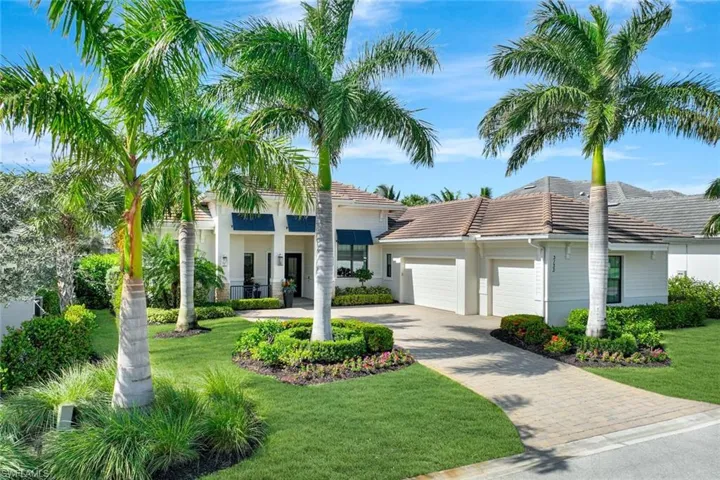 View of front of home with a front yard and a garage
