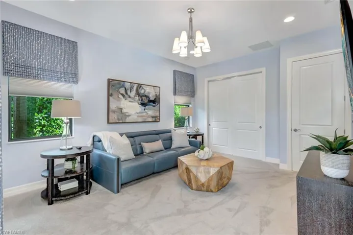 Carpeted living room with a notable chandelier