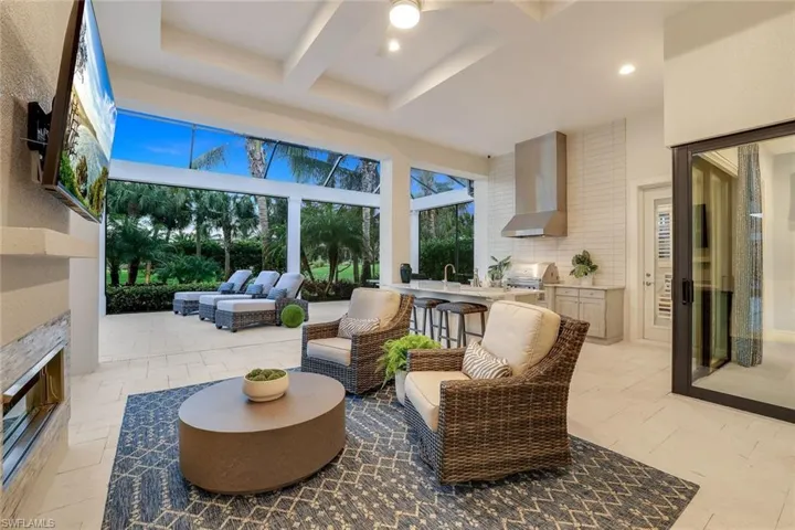 Sunroom with ceiling fan, exterior fireplace, beamed ceiling, sink, and coffered ceiling