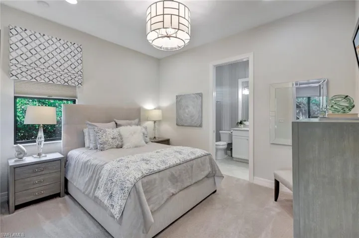 Carpeted bedroom featuring ensuite bathroom