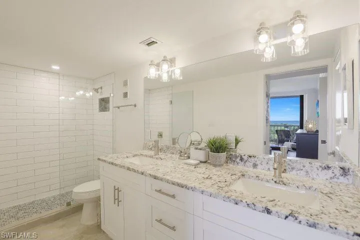 Full bath with double vanity, a stall shower, ensuite bathroom, and recessed lighting