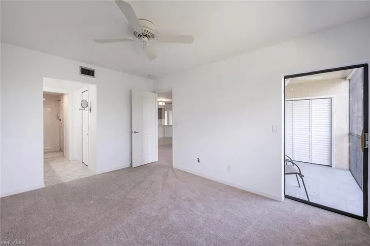 Unfurnished bedroom with ensuite bath, visible vents, a ceiling fan, and light colored carpet