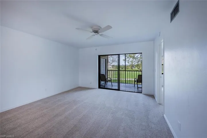 Carpeted empty room featuring baseboards, visible vents, and ceiling fan
