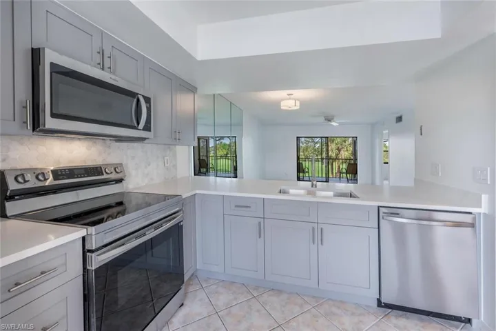 Kitchen featuring gray cabinets, a sink, and stainless steel appliances