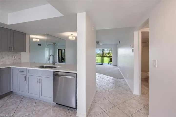Kitchen with ceiling fan, a sink, gray cabinets, and dishwasher