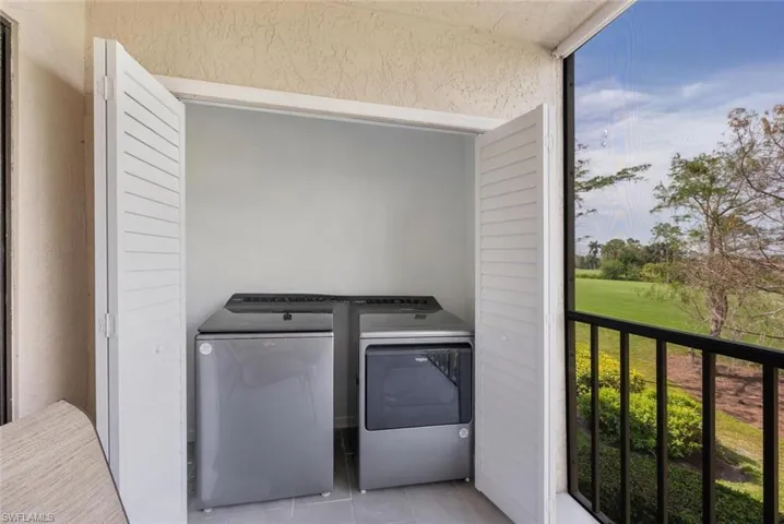 Laundry area featuring laundry area, tile patterned flooring, and washer and clothes dryer