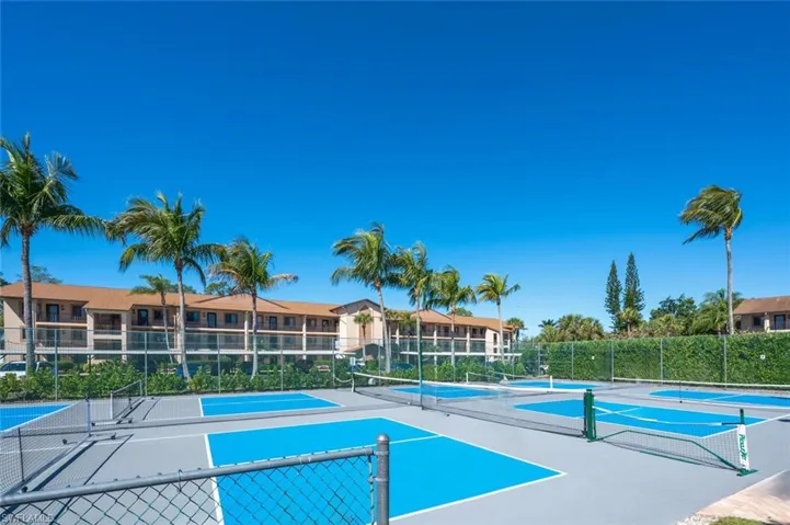 View of pool featuring a tennis court and fence