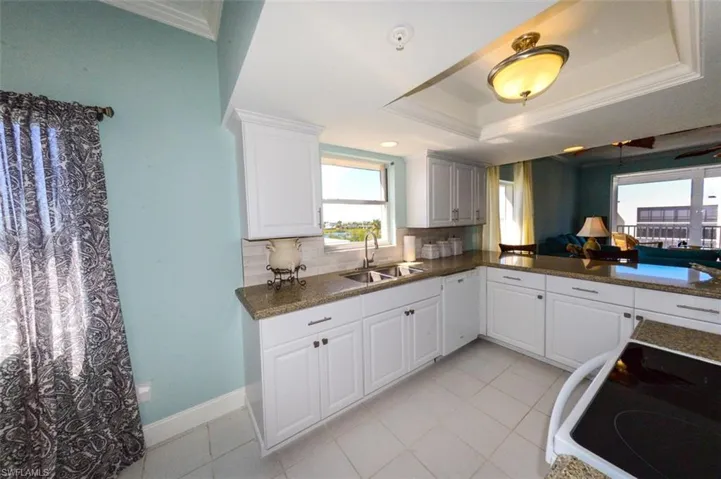 GRANITE COUNTERTOPS.  FULL-HEIGHT TILED BACKSPLASH.  UNDER-MOUNT STAINLESS STEEL SINK WITH HIGH ARC FAUCET.  RECESSED LIGHTING.  TRAY CEILING.