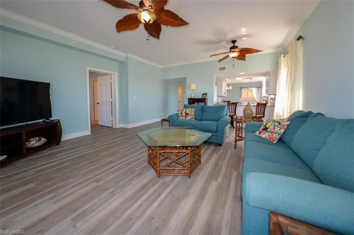 VIEW SHOWING ENTRANCE TO OWNER'S SUITE (MIDDLE)  UNIT ENTRANCE AND GUEST BEDROOM/BATH ARE AT MIDDLE REAR.  PLANK VINYL FLOORING.