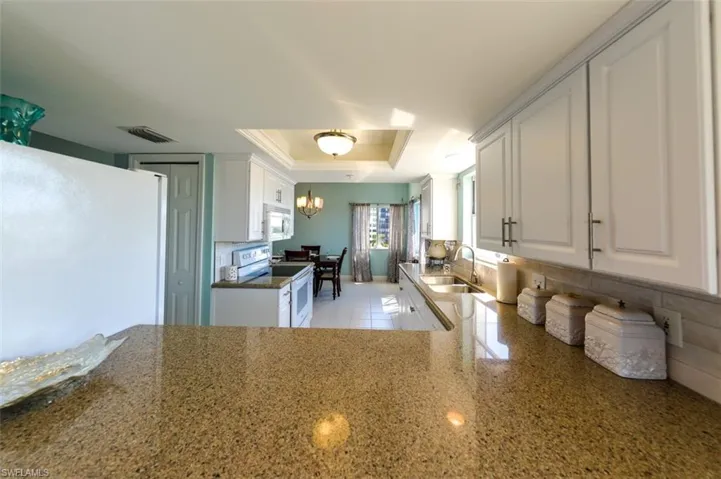 VIEW FROM BREAKFAST BAR INTO KITCHEN AND DINING AREAS.