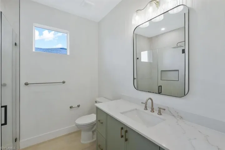 Full bathroom with vanity, a stall shower, and plenty of natural light