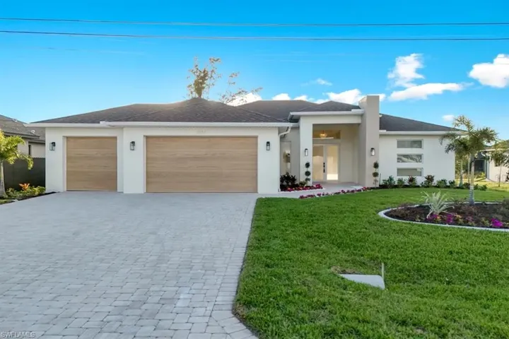 View of front of property with a front lawn, decorative driveway, stucco siding, a garage, and a shingled roof