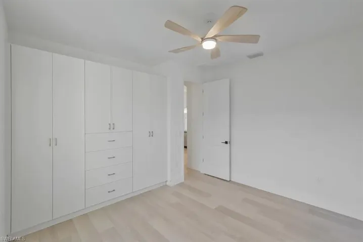 Unfurnished bedroom with light wood-style floors and a ceiling fan