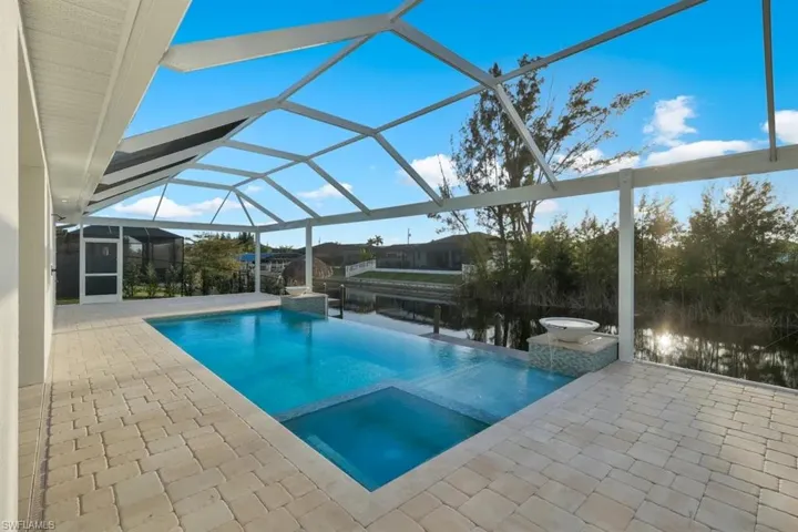Combined pool / hot tub featuring a patio area, a sunroom, and a lanai