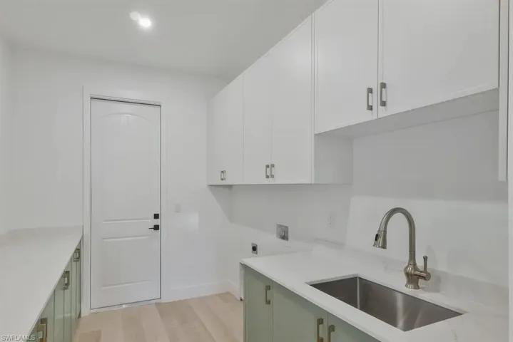 Laundry area with cabinet space, light wood-type flooring, electric dryer hookup, recessed lighting, and hookup for a washing machine