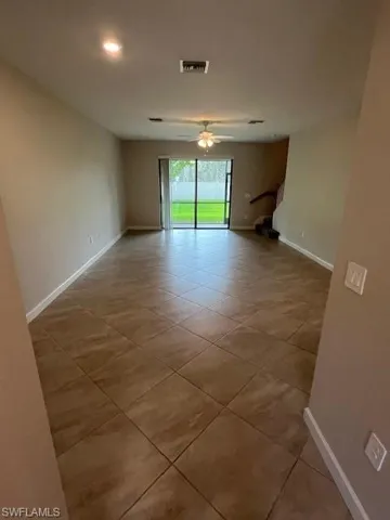Unfurnished room featuring light tile patterned floors and a ceiling fan