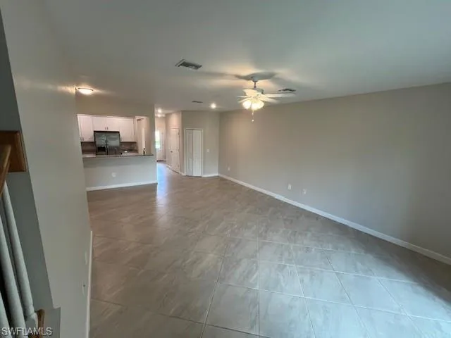 Unfurnished living room with a ceiling fan and light tile patterned floors