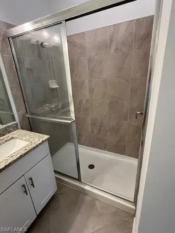 Bathroom featuring vanity, a stall shower, and tile patterned flooring