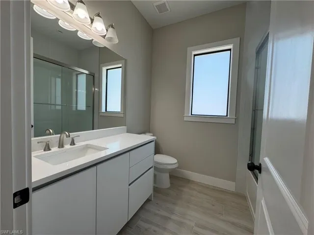 Full bathroom with healthy amount of natural light, bath / shower combo with glass door