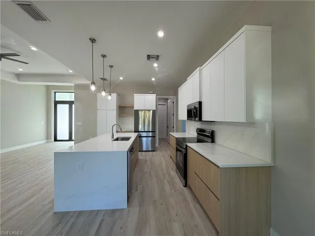 Two tone kitchen with modern cabinets, two tone cabinetry, stainless steel appliances.