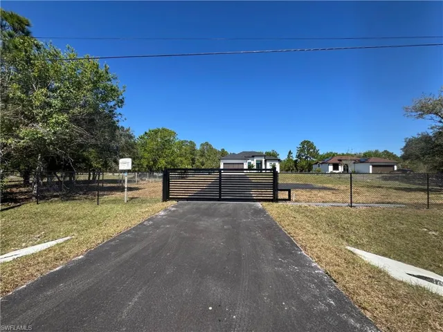 View of asphalt driveway with a gated entry and a gate