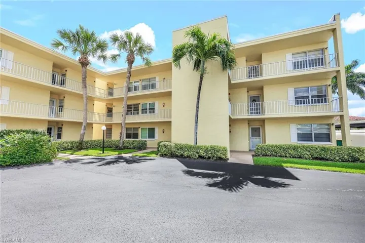 View of apartment building / complex with uncovered parking
