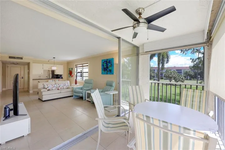 Sunroom with a ceiling fan, a balcony, and an outdoor living / dining area