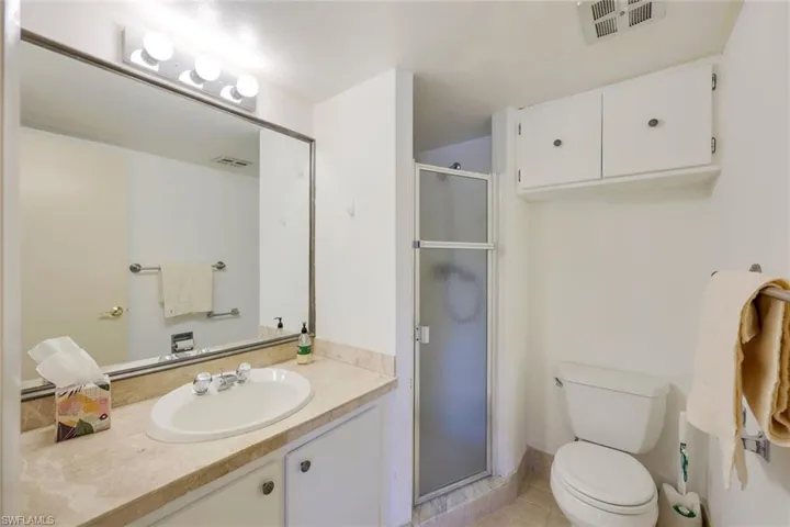 Bathroom with vanity, a stall shower, and light tile patterned floors