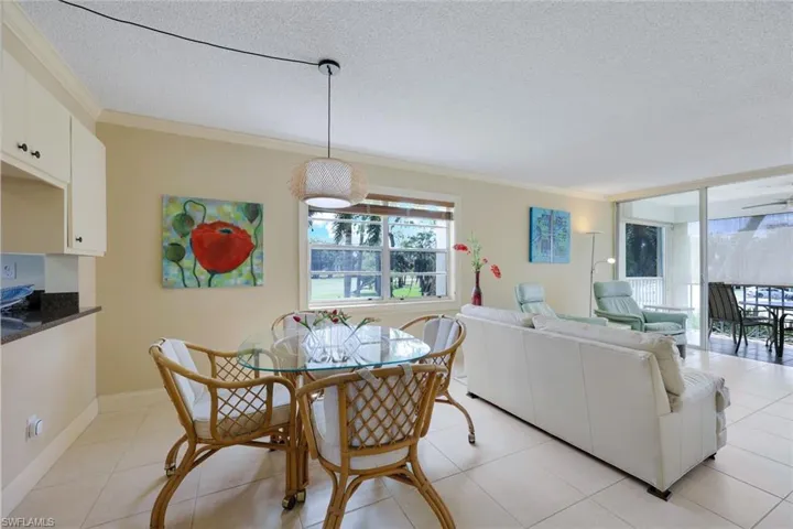 Dining space with a textured ceiling, ornamental molding, and light tile patterned floors