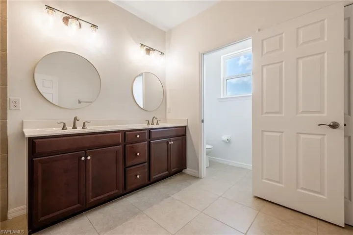 Primary ensuite Bathroom with double vanity and tile patterned flooring