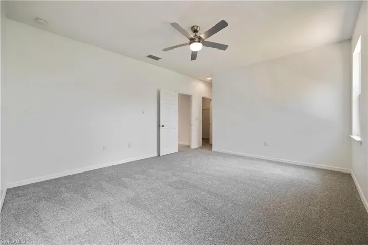 Primary Bedroom with ceiling fan, carpet floors, and a smoke detector