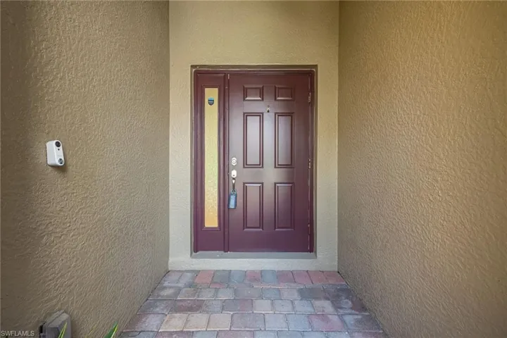 Doorway to property featuring stucco siding