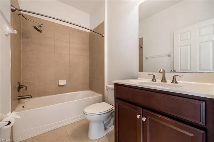 Full bathroom with tile patterned flooring, vanity, and bathing tub / shower combination