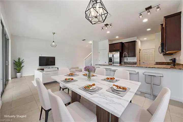 Dining space with light tile patterned flooring and recessed lighting Virtually Staged
