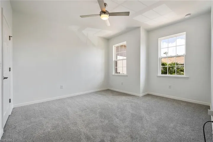 Carpeted guest room featuring a ceiling fan and a smoke detector