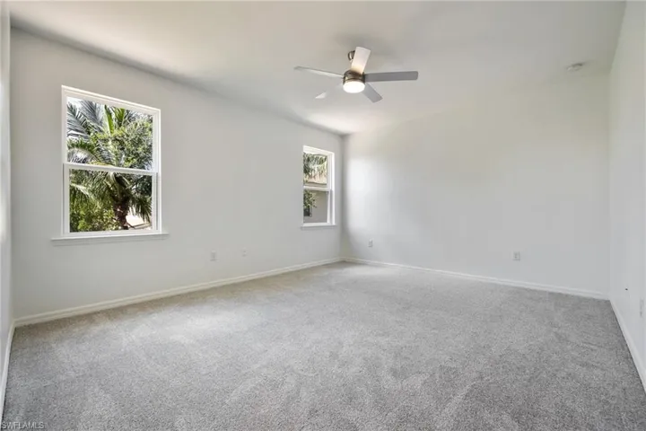 Primary Bedroom featuring plenty of natural light, a ceiling fan, carpet, and a smoke detector
