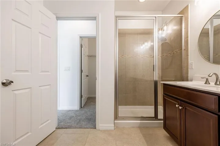 Primary ensuite Bathroom featuring a stall shower, vanity, and tile patterned floors