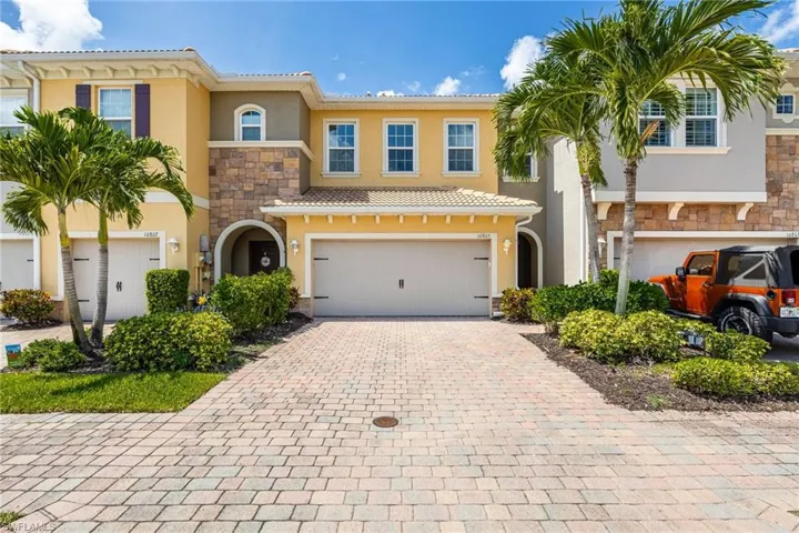 View of front of house featuring stucco siding, stone siding, an attached garage, decorative driveway, and a tiled roof