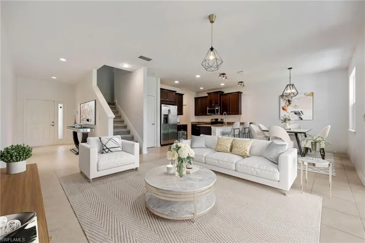 Virtually Staged Living room featuring light tile patterned flooring, stairs, and recessed lighting