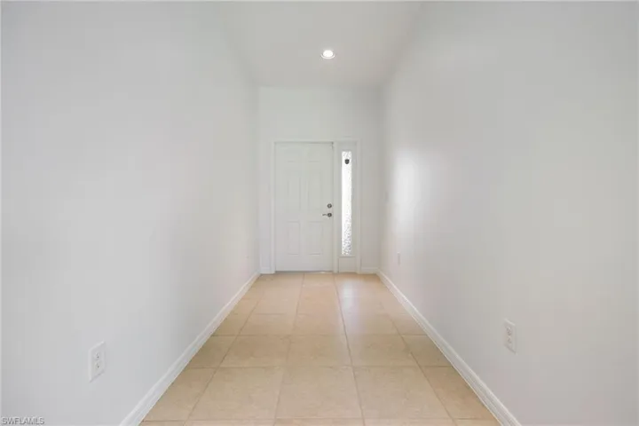 Hall featuring light tile patterned floors and recessed lighting
