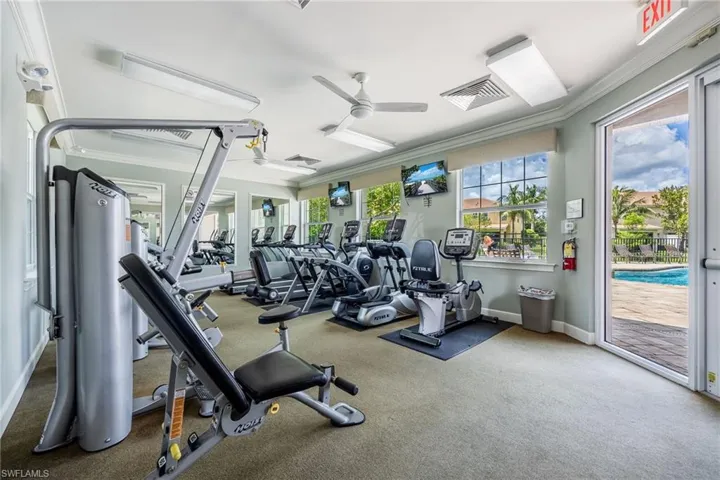 Workout area featuring crown molding, ceiling fan, and carpet floors