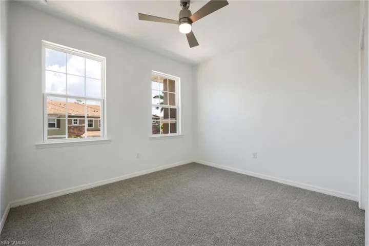 Guest room with carpet floors and ceiling fan